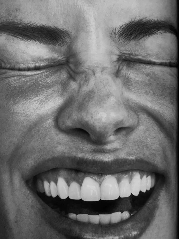 Persona sonriendo con los ojos cerrados